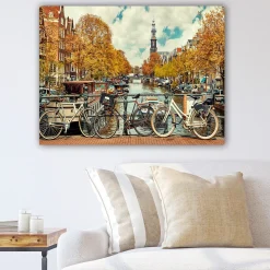 Lerretsbilde 70x100 cm - Sykler ved en kanal i Amsterdam omgitt av høstfarger